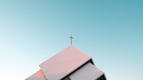 the roof of a church with a cross at the peak