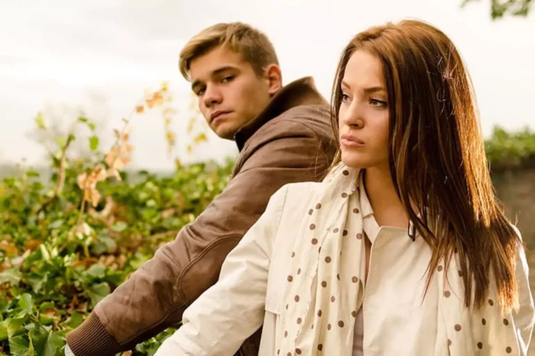 A couple looks distant and troubled while outdoors, visually representing the emotional strain that can come from living together before marriage.
