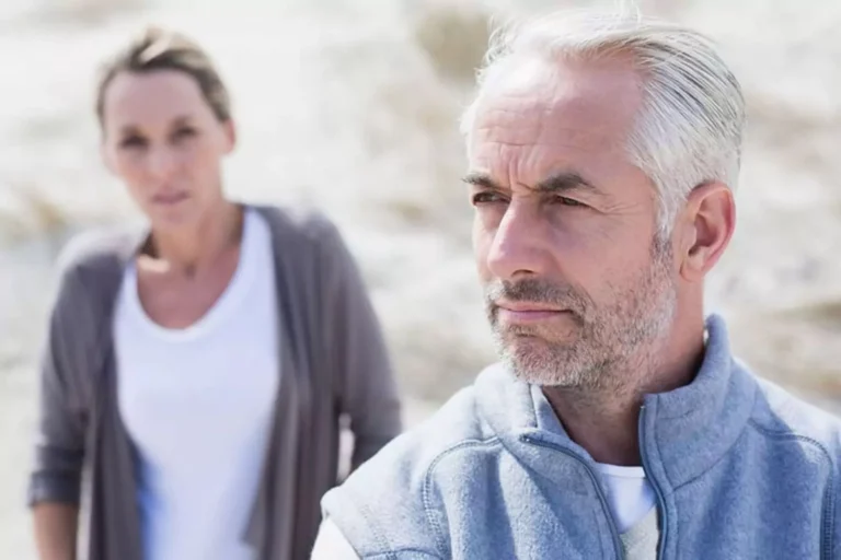 What husbands need to know about menopause — a serious-looking couple stands outdoors, reflecting emotional distance and the need for understanding.