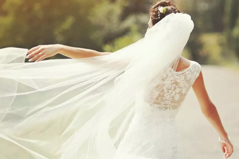A bride in a flowing white gown with a long veil, symbolizing purity, joy, and qualities to consider when thinking about what to look for in a future wife.