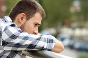Man sitting with his head in his arms. He is deep in thought