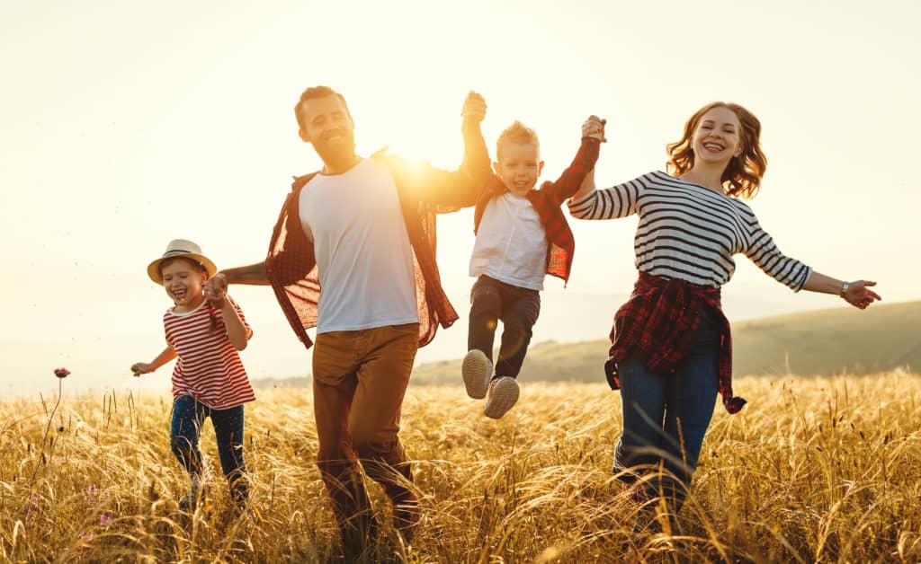 Happy family of four at sunset.