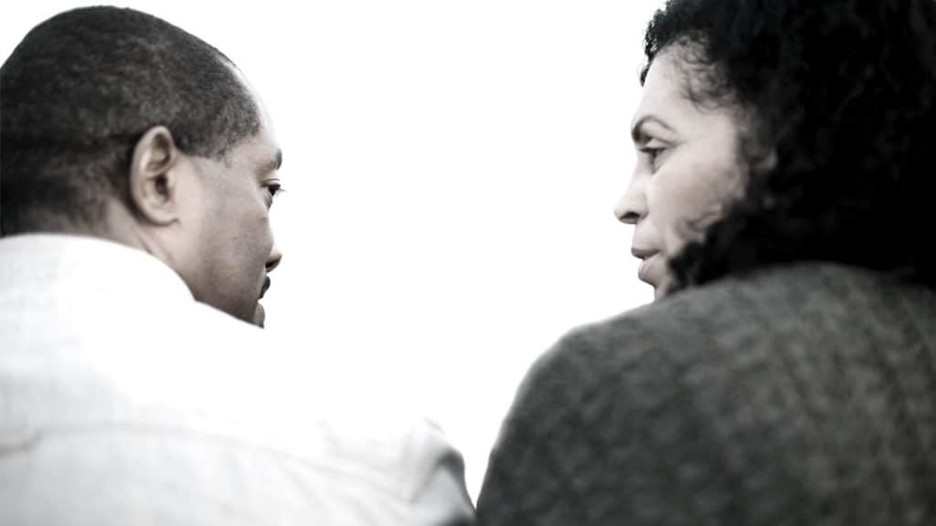 Shown from behind, close up of middle age black couple having a serious conversation