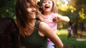 A woman demonstrates God's love for the disabled. Little girl with special needs enjoy spending time with mother