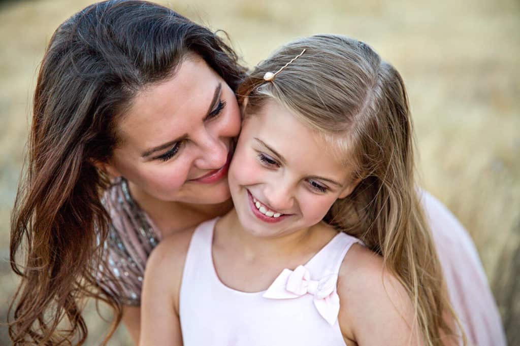 Raising healthy resilient kids through love as seen by mom hugging daughter