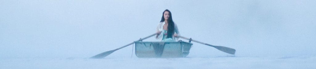 Woman In Row Boat On A Foggy New England Morning