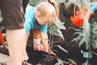 Responsible kids are taught like this young girl working in the garden with her mother.