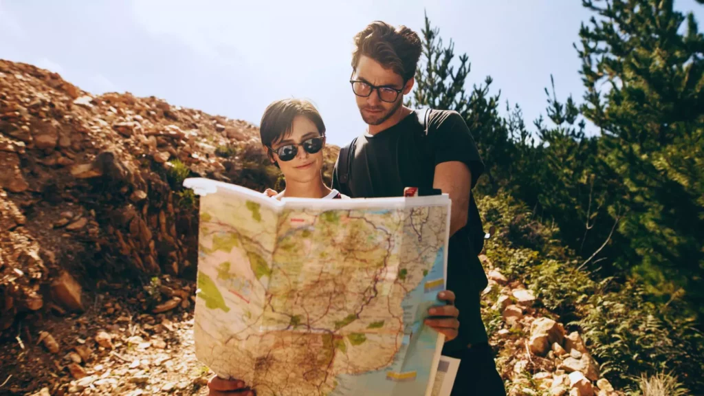 Adventuring newlywed couple looks at a map, trying to avoid potential pitfalls.