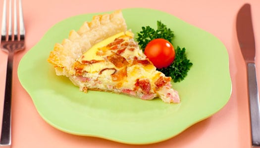 Close up of a slice of quiche on a plate