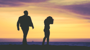 Couple standing on the beach at sunset