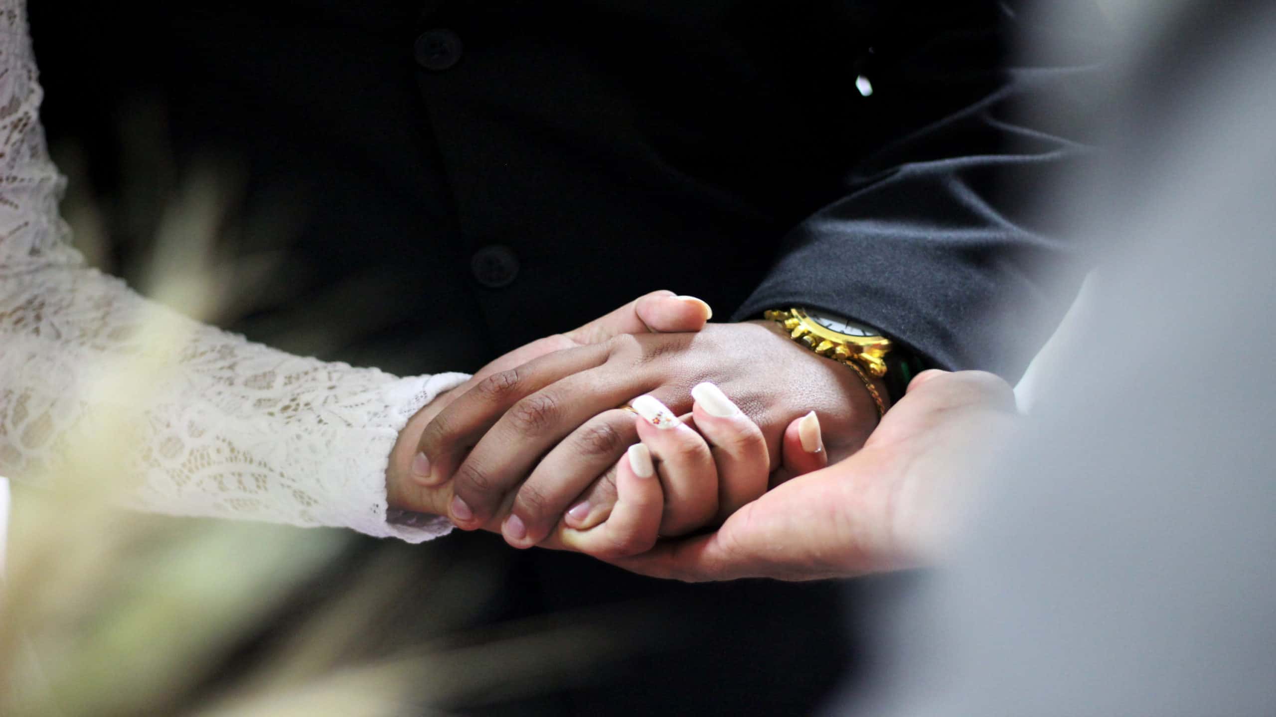 a man and woman hold hands during a wedding