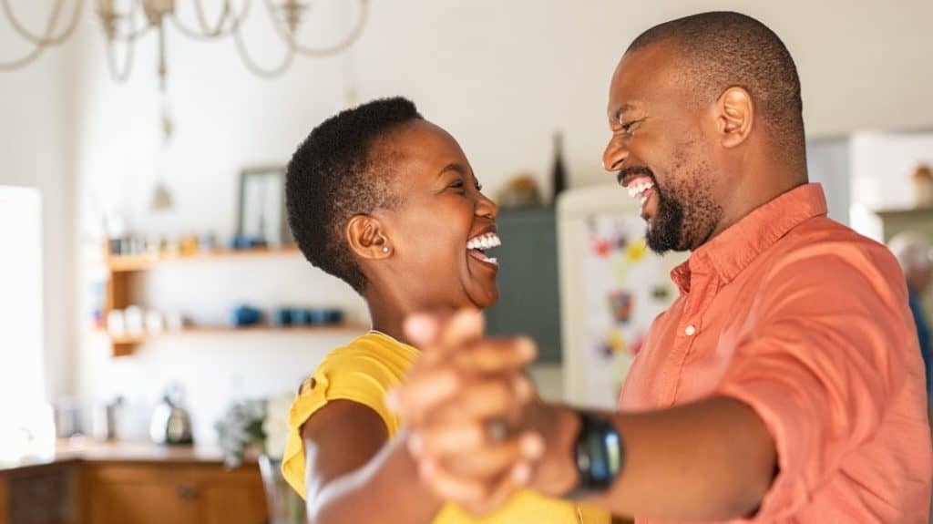 Husband and wife laughing and dancing in their home