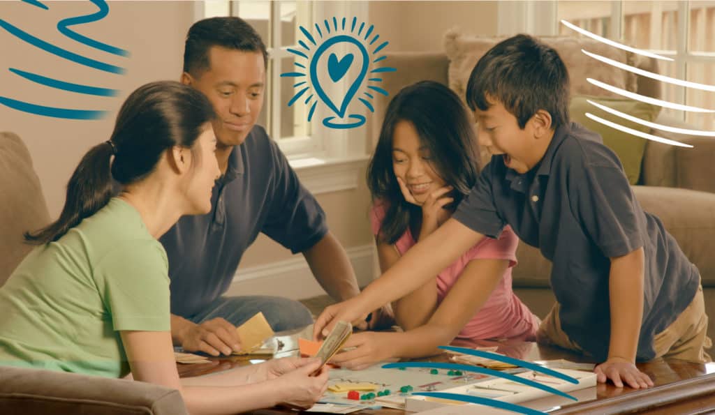 Family having fun playing a board game in their living room