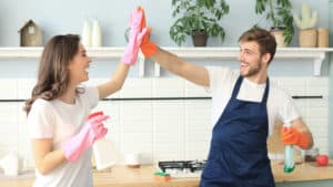 couple high-fiving while doing household chores