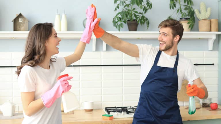 couple high-fiving while doing household chores