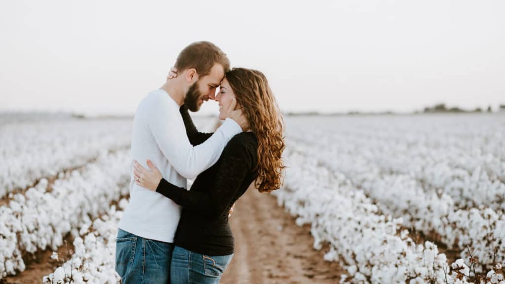 Engaged couple in field processing postponed wedding plans