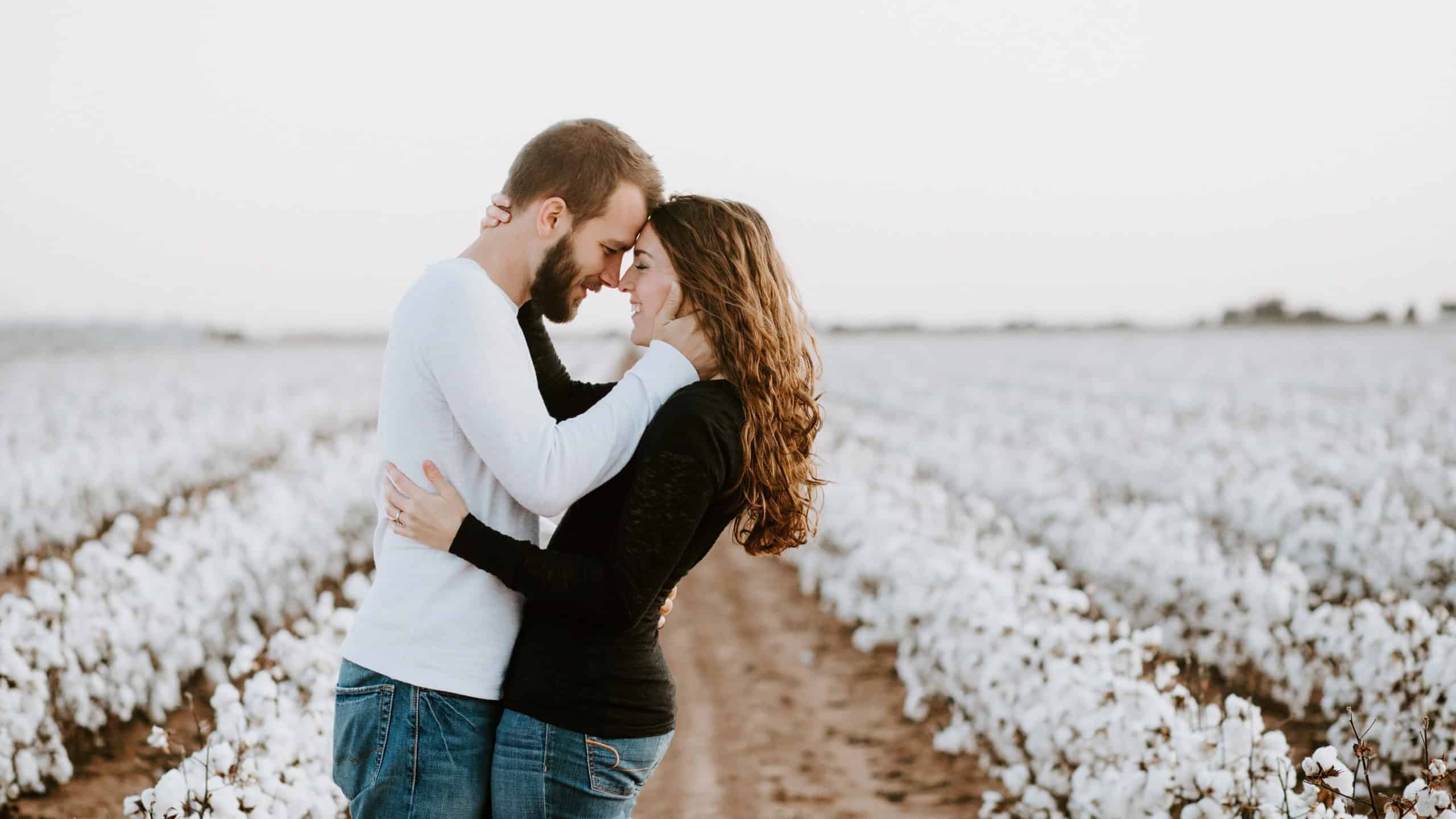 Engaged couple in field processing postponed wedding plans