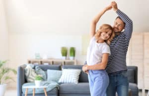 a man and woman dance together in their home