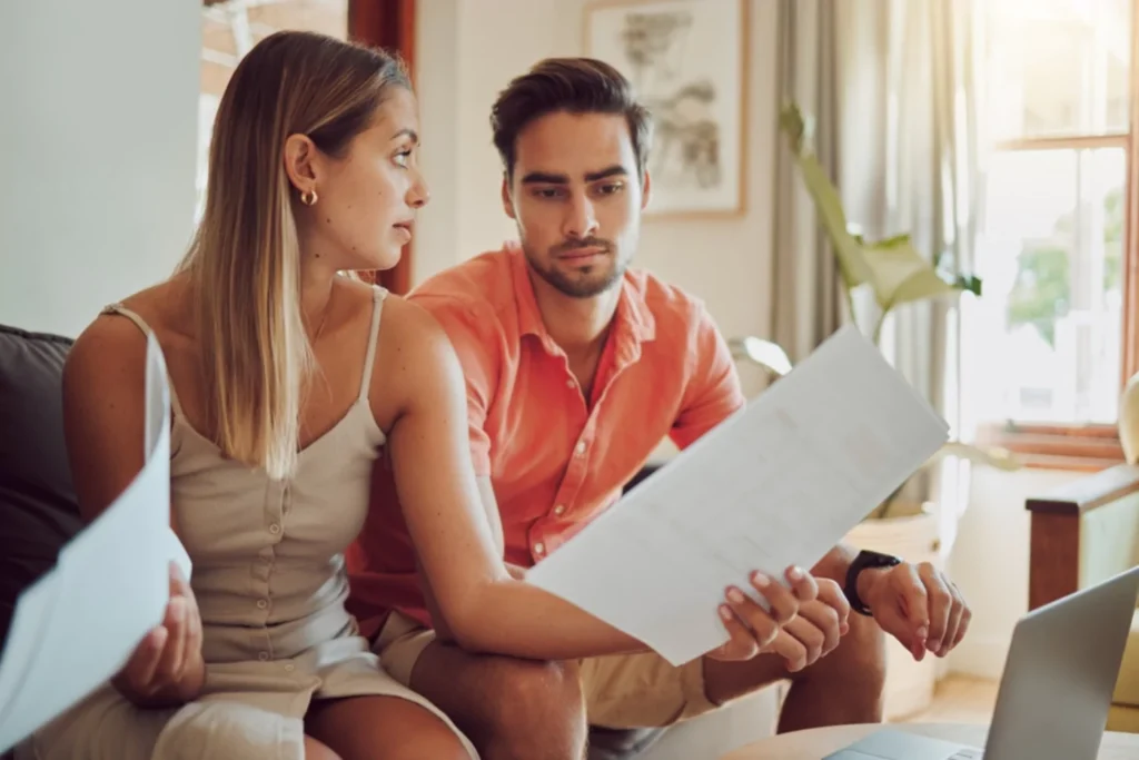 Couple reviewing documents at home, facing financial infidelity in their marriage.