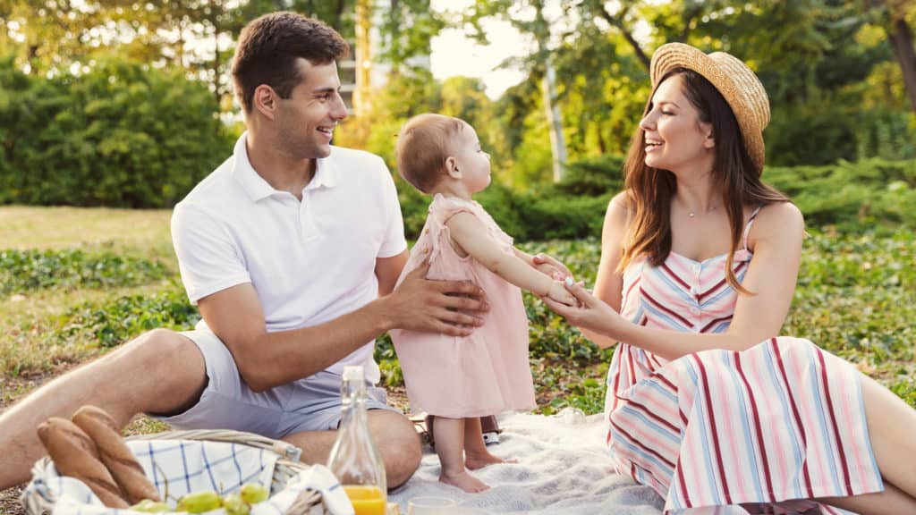 Young parents on romantic date picnic with baby