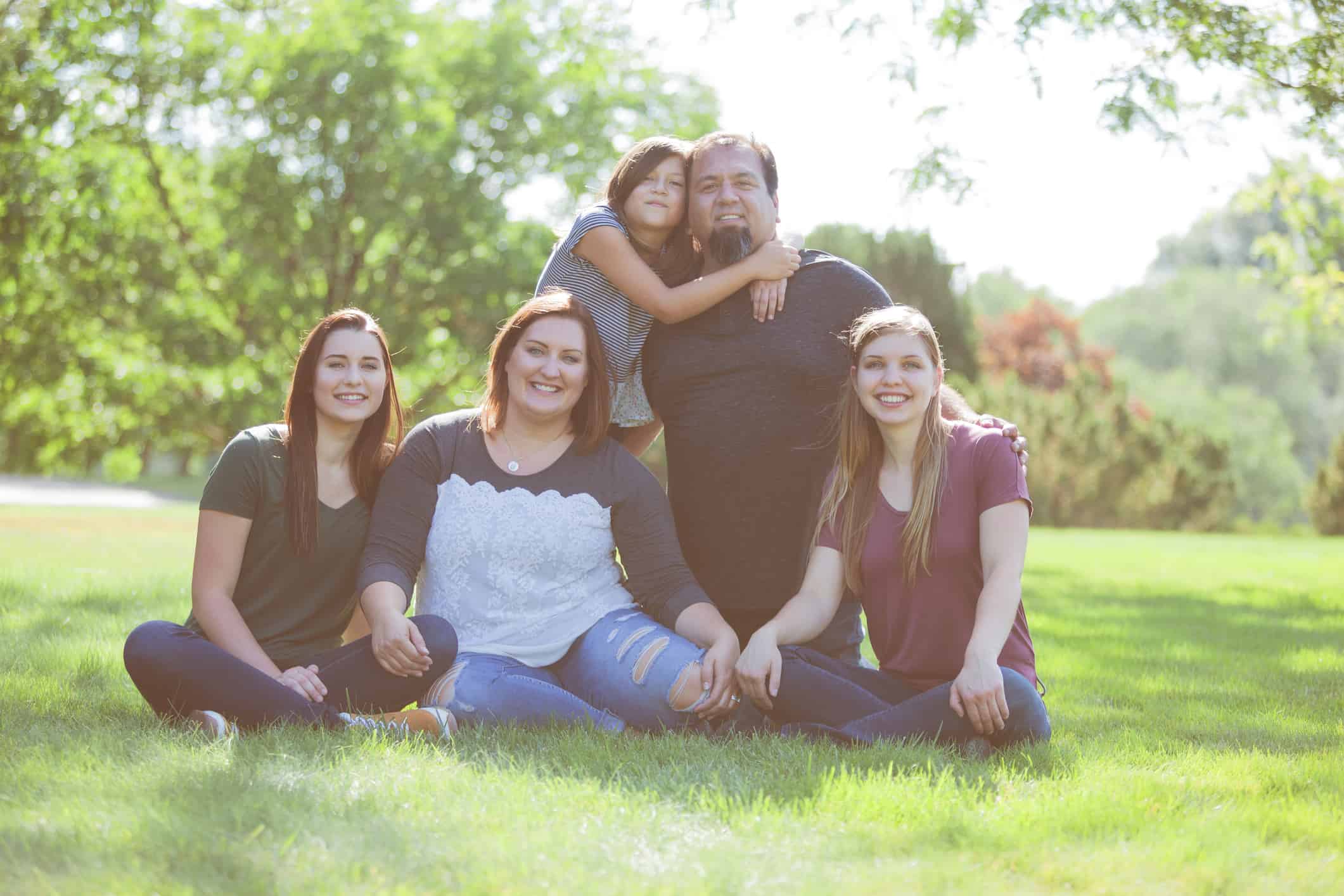 Smiling family posing for a photo in the park