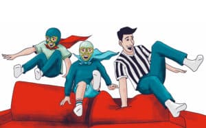 Siblings in luchador costumes jumping over a couch with their father dressed as a referee.