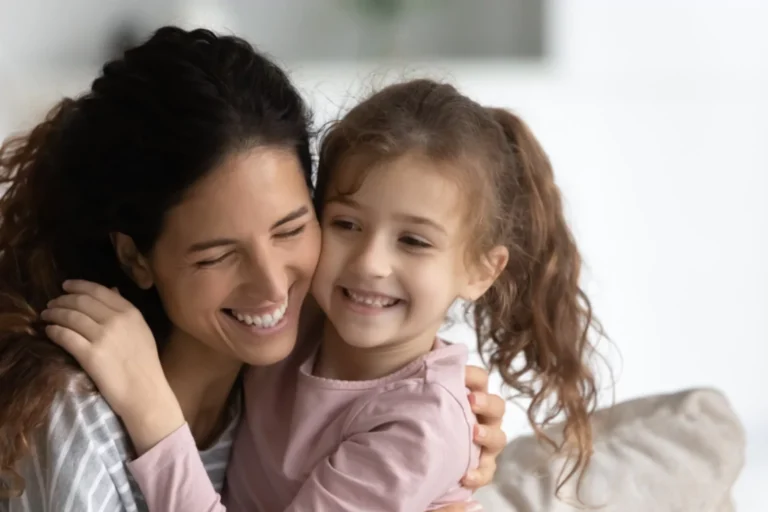 Smiling mother and daughter hugging, representing love and resilience in the midst of single parent struggles.