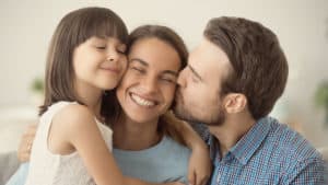 daughter and husband kiss mom