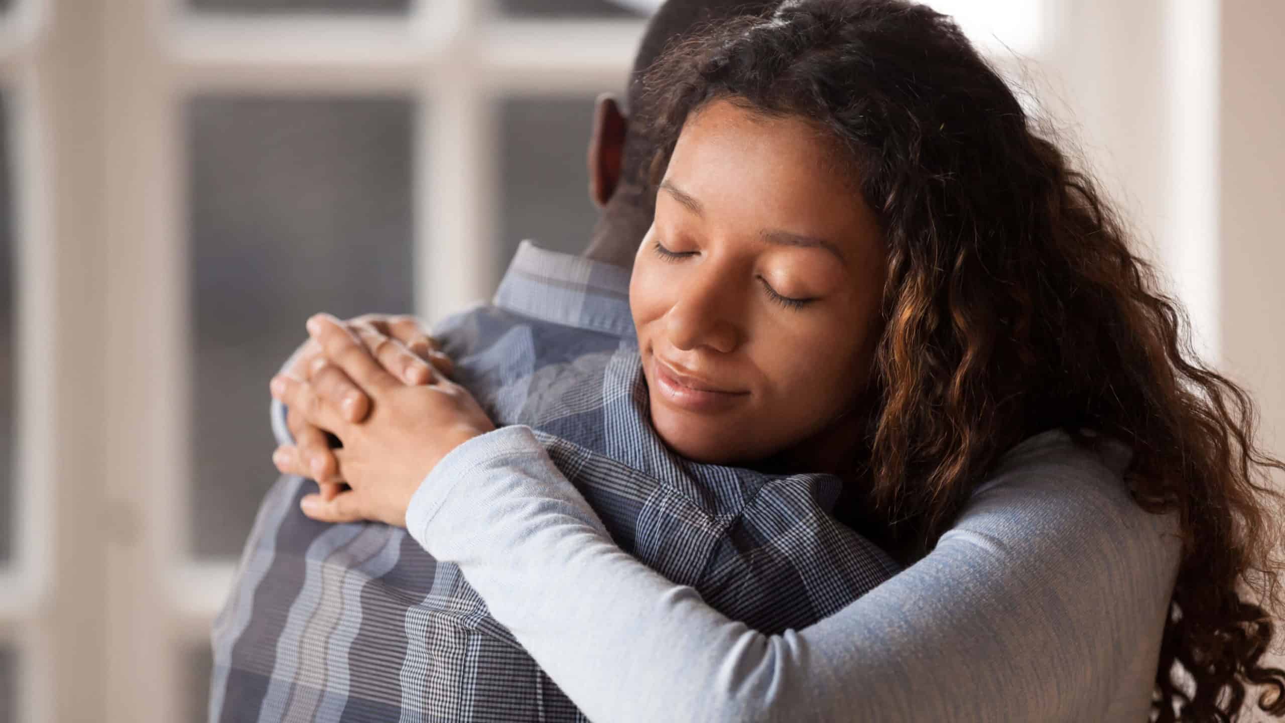 a woman hugs her husband