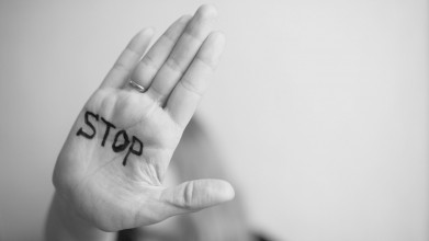 Woman holding out STOP written on hand for setting boundaries