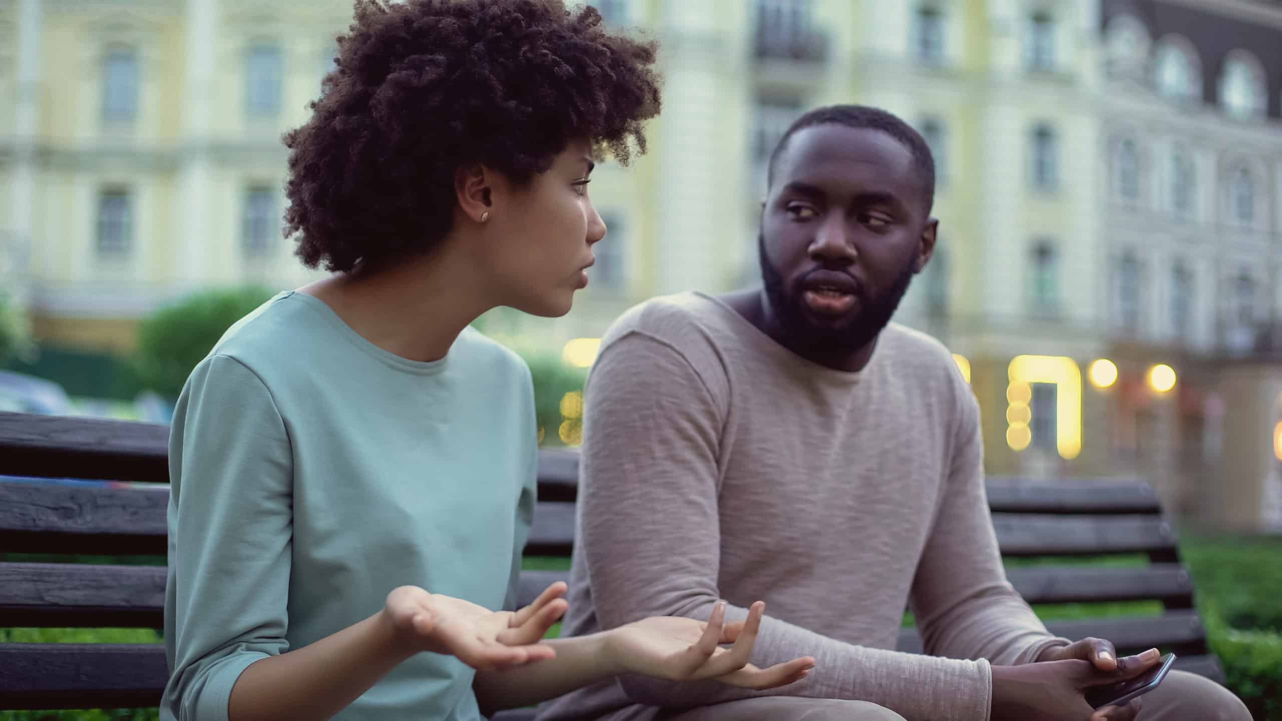 couple arguing on park bench_ overwhelmed spouse