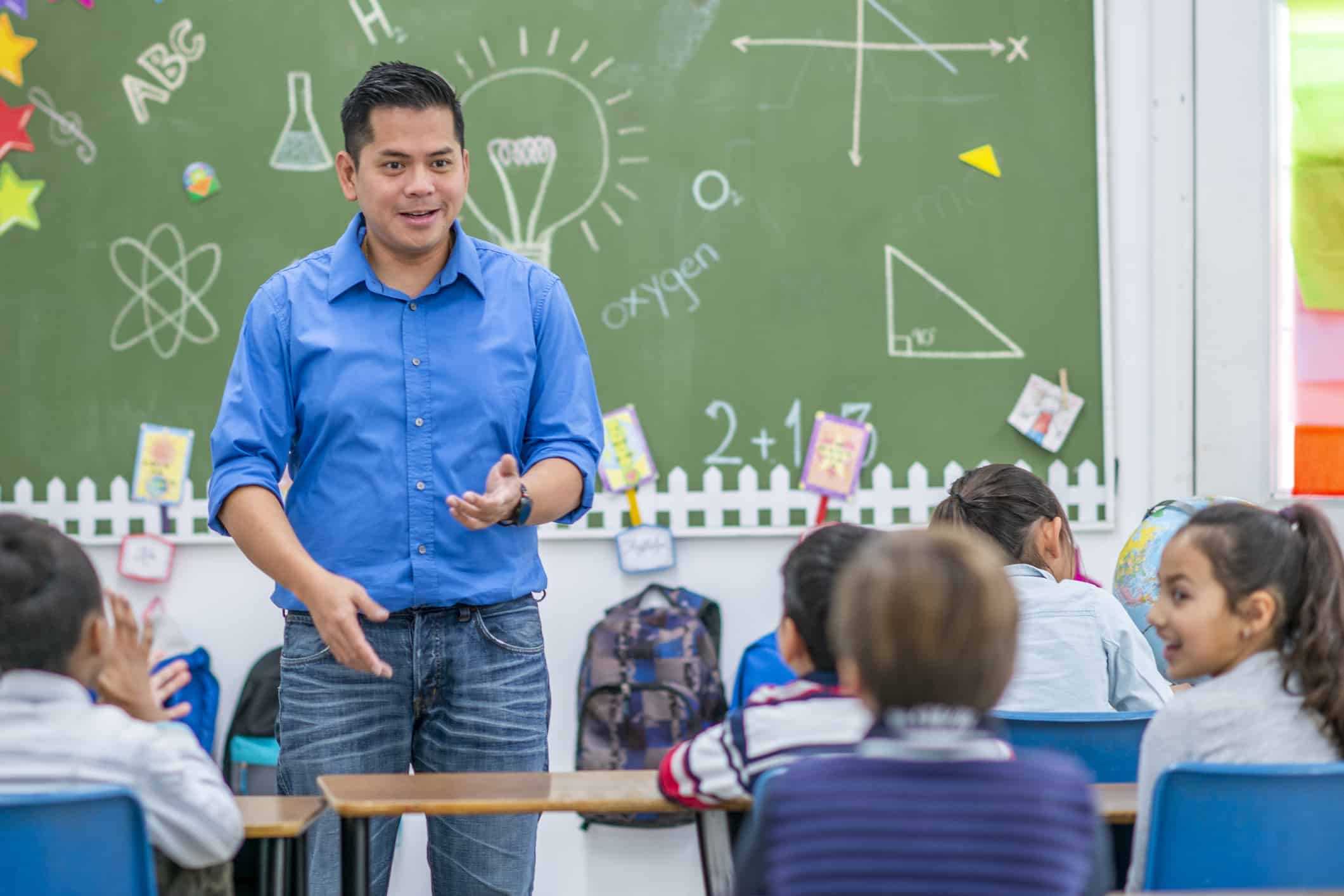 Teacher explaining something to young children in a school classroom