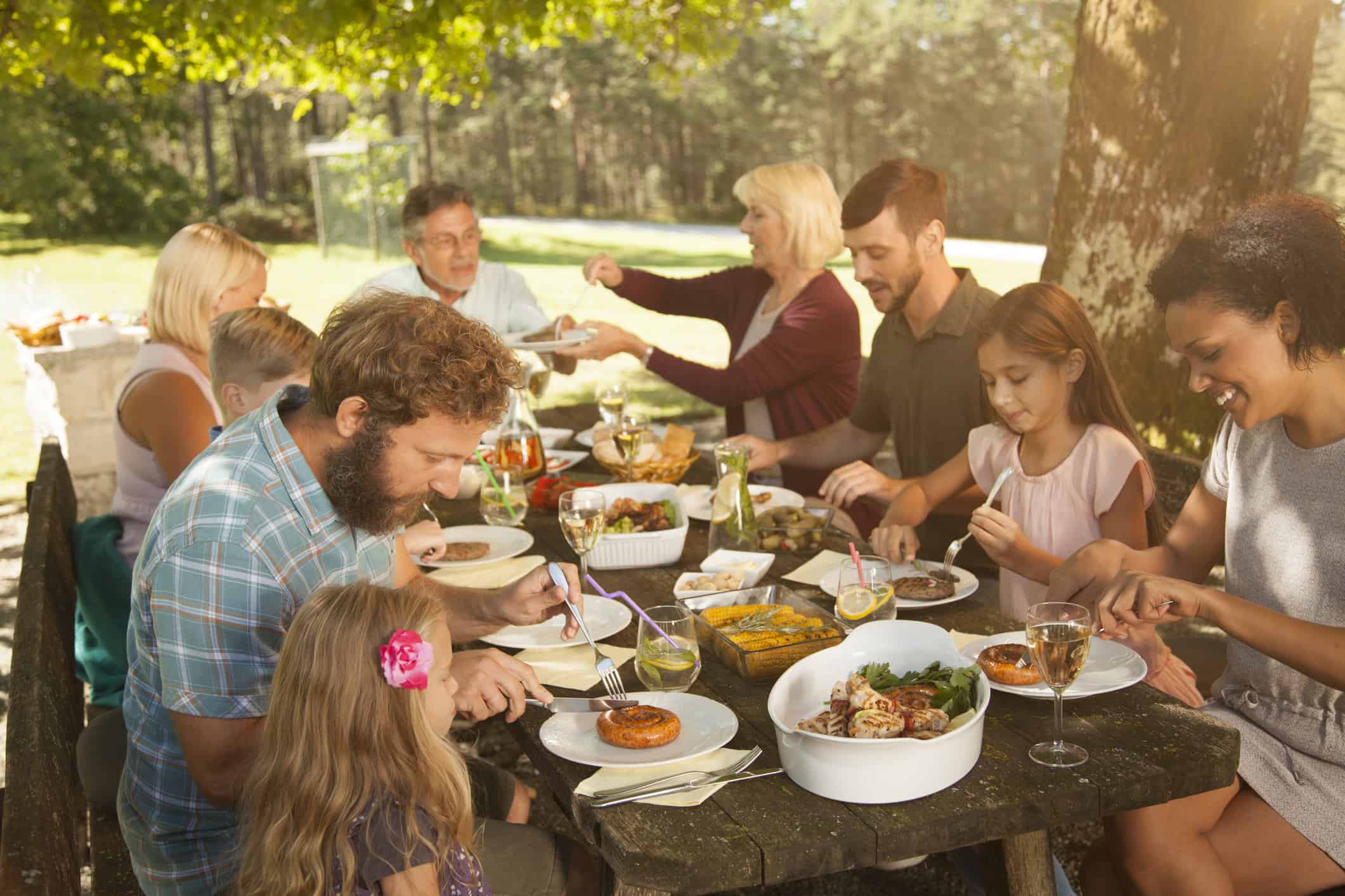 Едим на свежем воздухе. Семейное застолье. Семья за столом. Семейный обед на природе. Большая семья за праздничным столом.