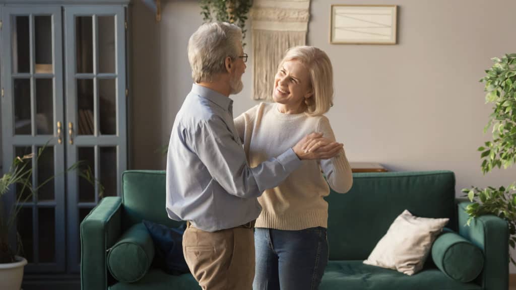 Older couple dancing in living room learning how to live just the two of you after empty nest