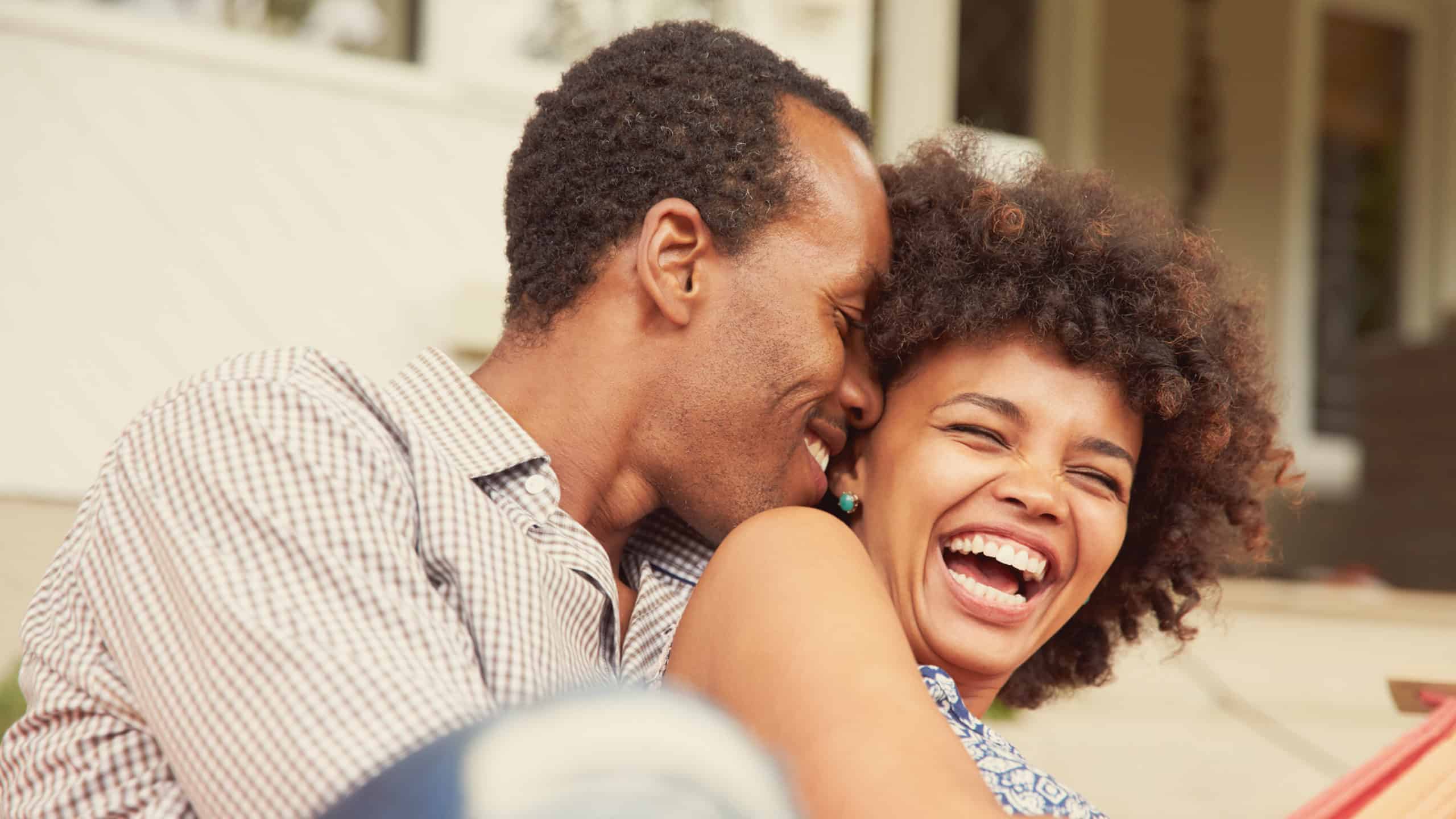 Smiling husband cuddling with his laughing wife