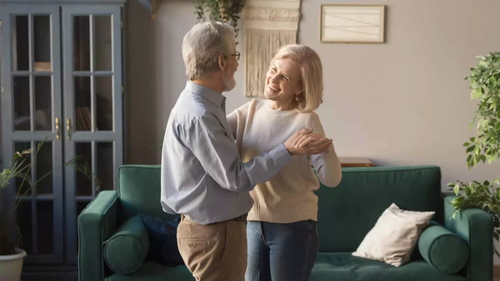 Older couple dancing in living room learning how to live empty nest now the kids are grown