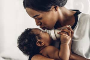 A loving mother kisses her baby