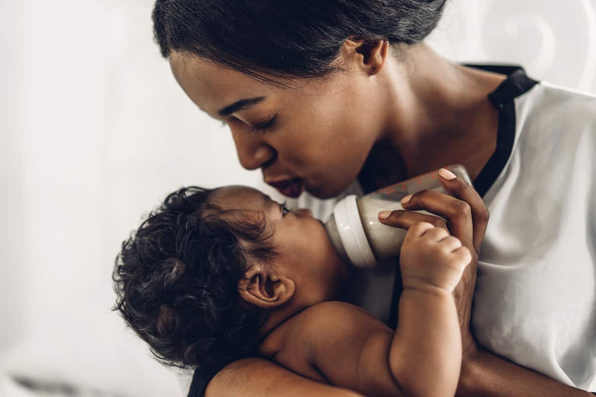 A loving mother kisses her baby