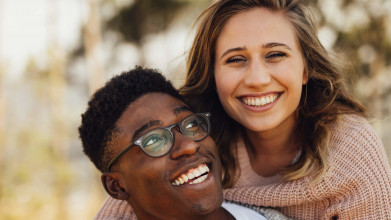 An interracial couple smiles for the camera