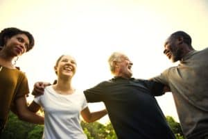 care community standing in circle locking arms