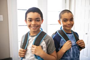 two boys in foster care with backpacks