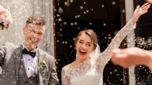 a man and woman are showered with rice and confetti after their wedding