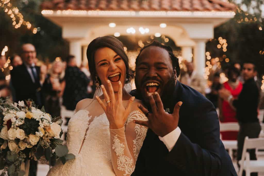 a newly married couple showing off their rings