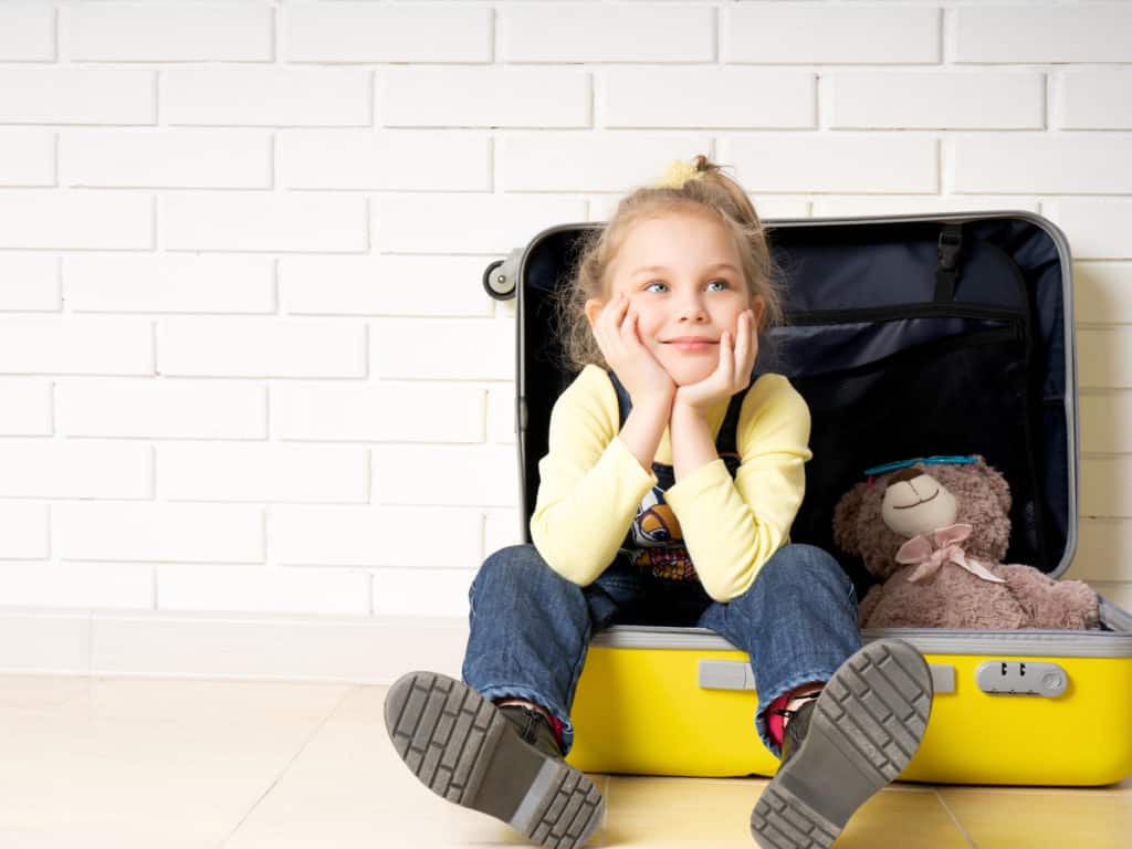 Little girl and bear in suitcase