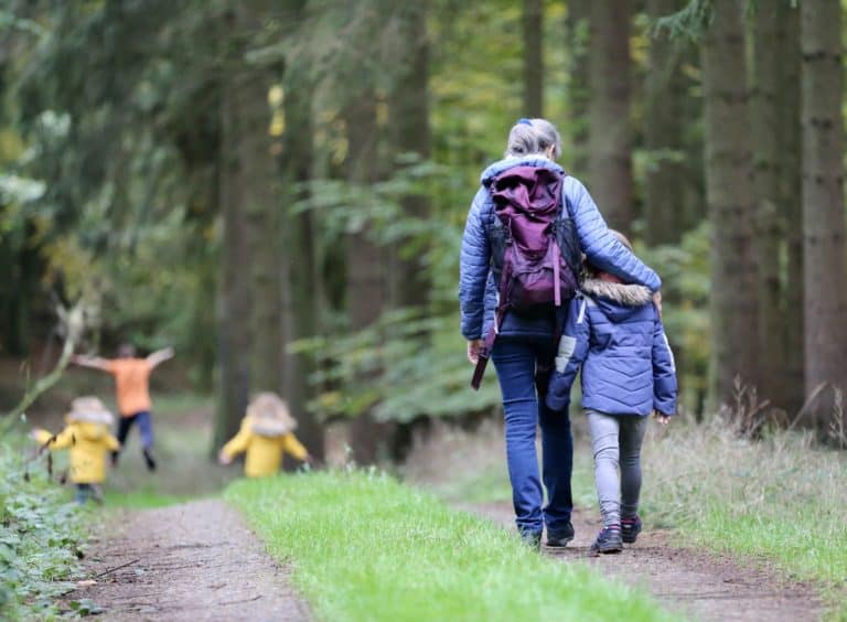 Grandmother walking with grandchildren in forest