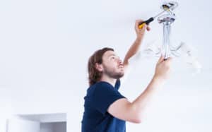 Inner Handyman - A man working on the electrics of a lamp.