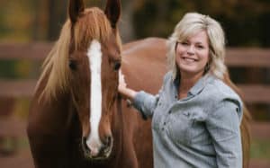 Photo of Kim with an abused horse from her ministry Hope Reigns, supported by her spouse Mike.