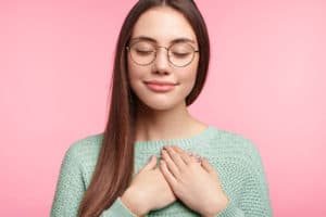 a woman placing her hands over her heart