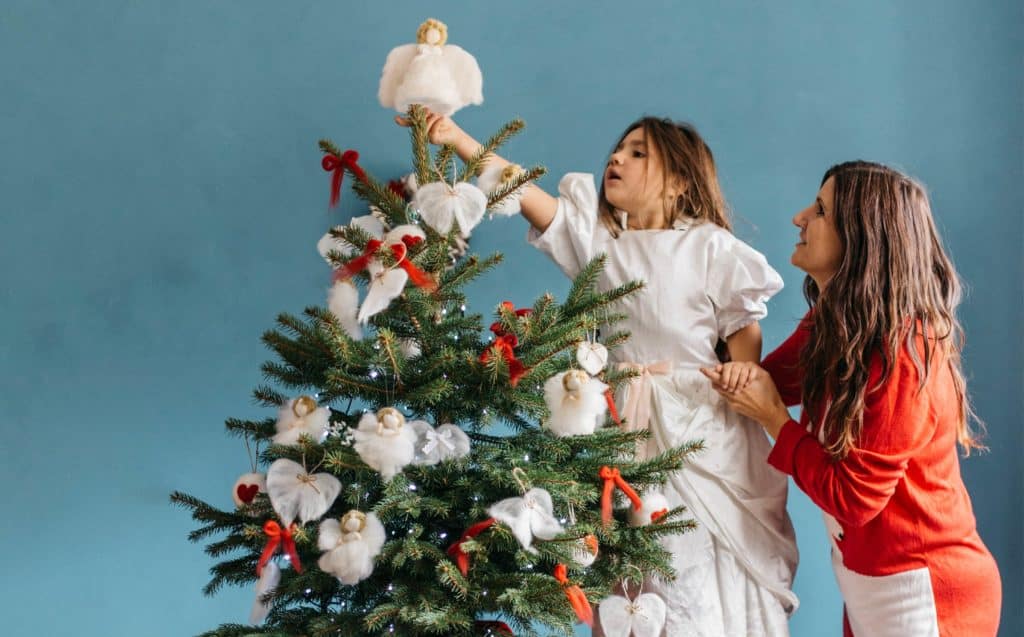 fun and faith activities - little girl and mother decorate the Christmas tree