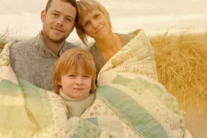 adoptive family wrapped in quilt